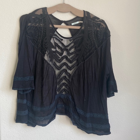 Black top with mesh, lace and beading detail throughout, open back.